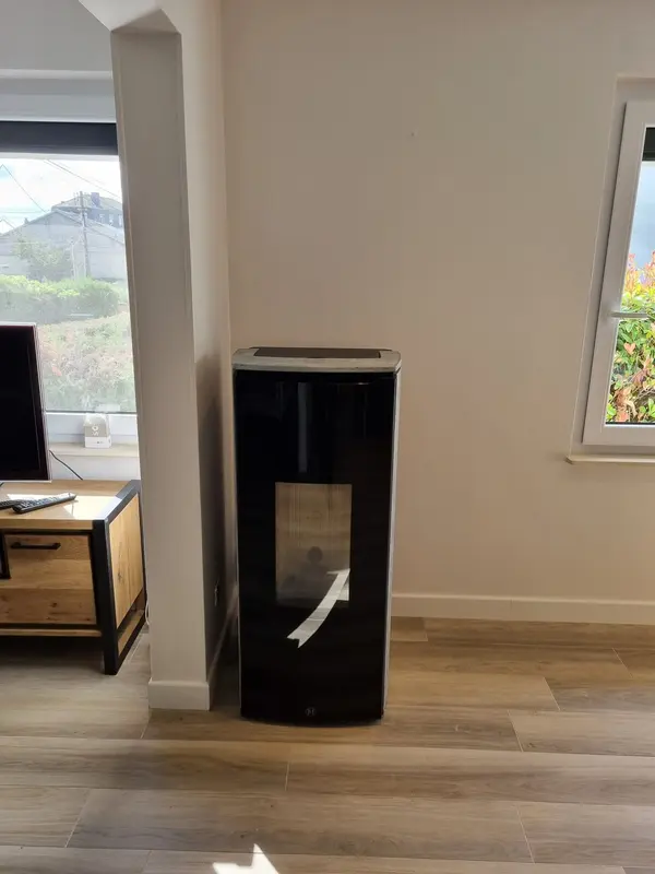 Poêle à granulés colonne noir tout juste installé, film de protection encore sur la vitre