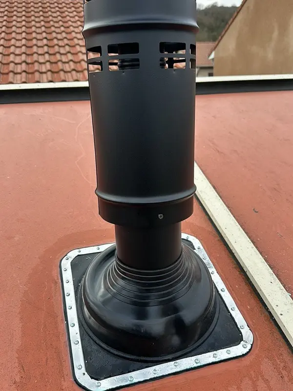 Sortie de toit noire avec platine d'étanchéité sur un toit plat